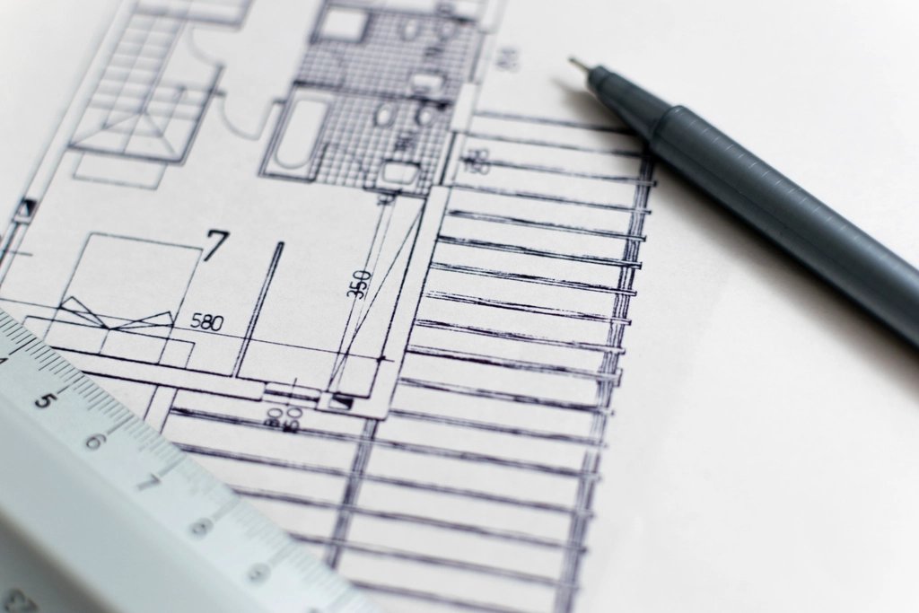 Close-up of an architectural floor plan with a pen and scale ruler